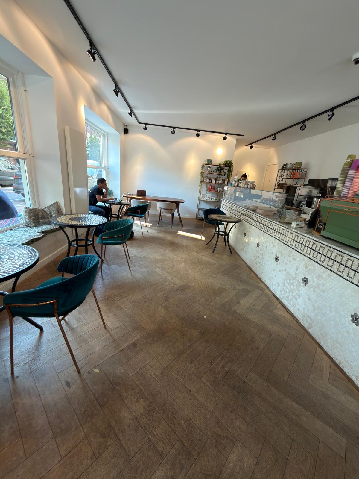 Interieur van Sip Spot met visgraatvloer en groene stoelen