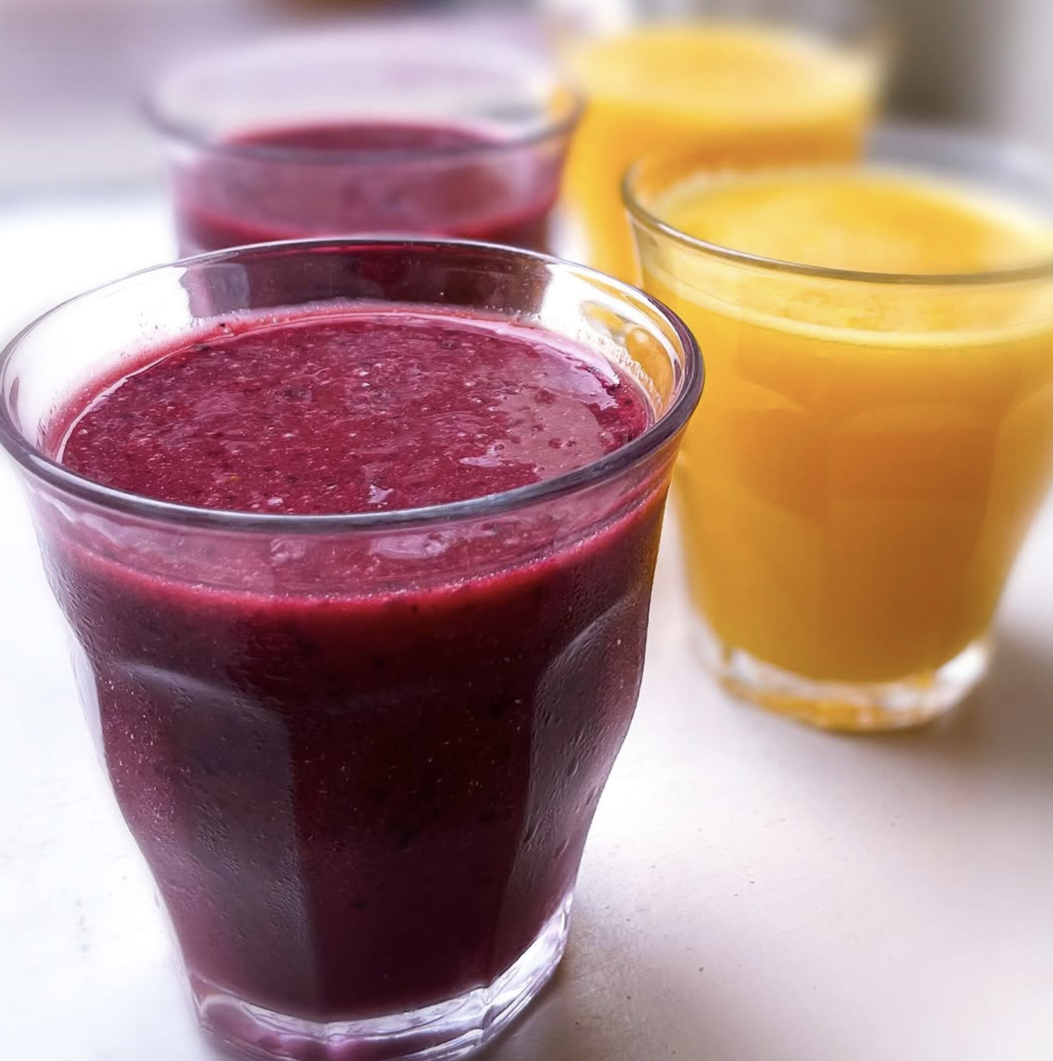 Vers geperste sinaasappelsap en groene juice in glazen