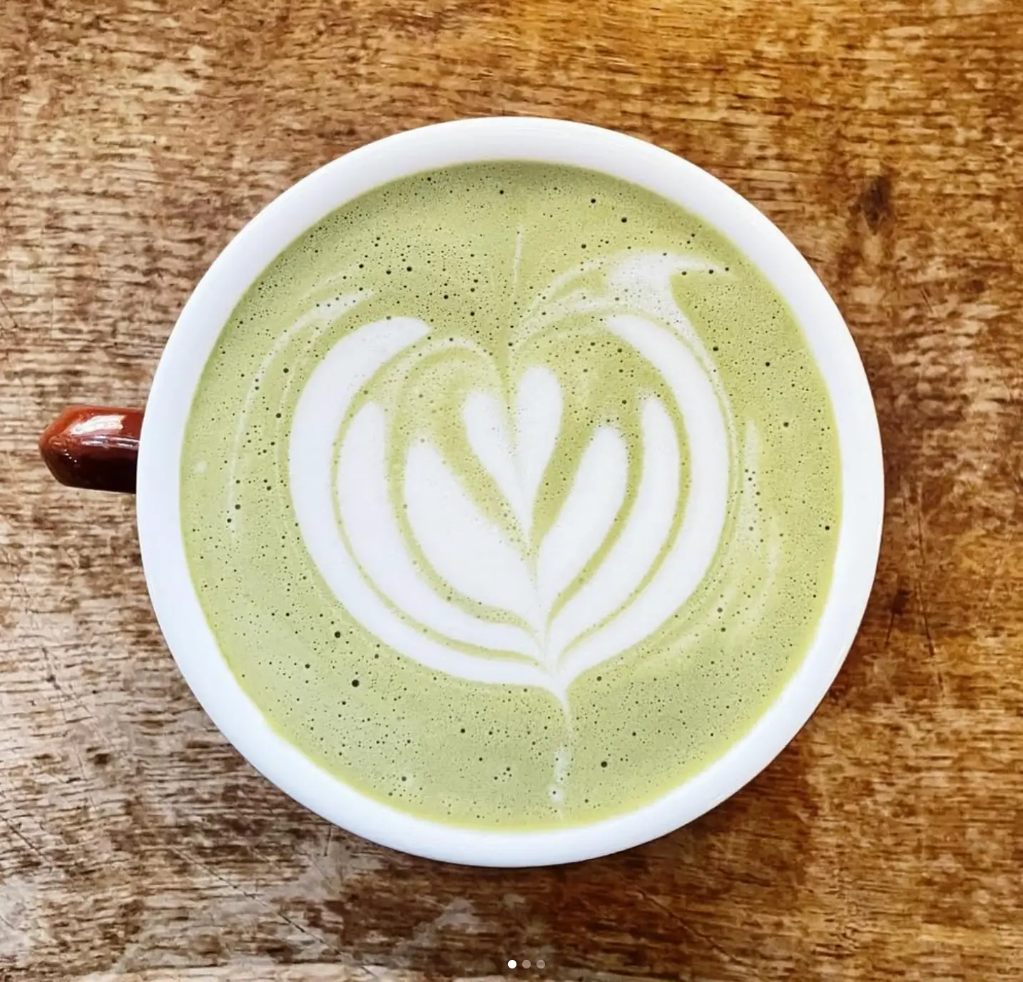 Matcha latte en cappuccino met latte art naast elkaar