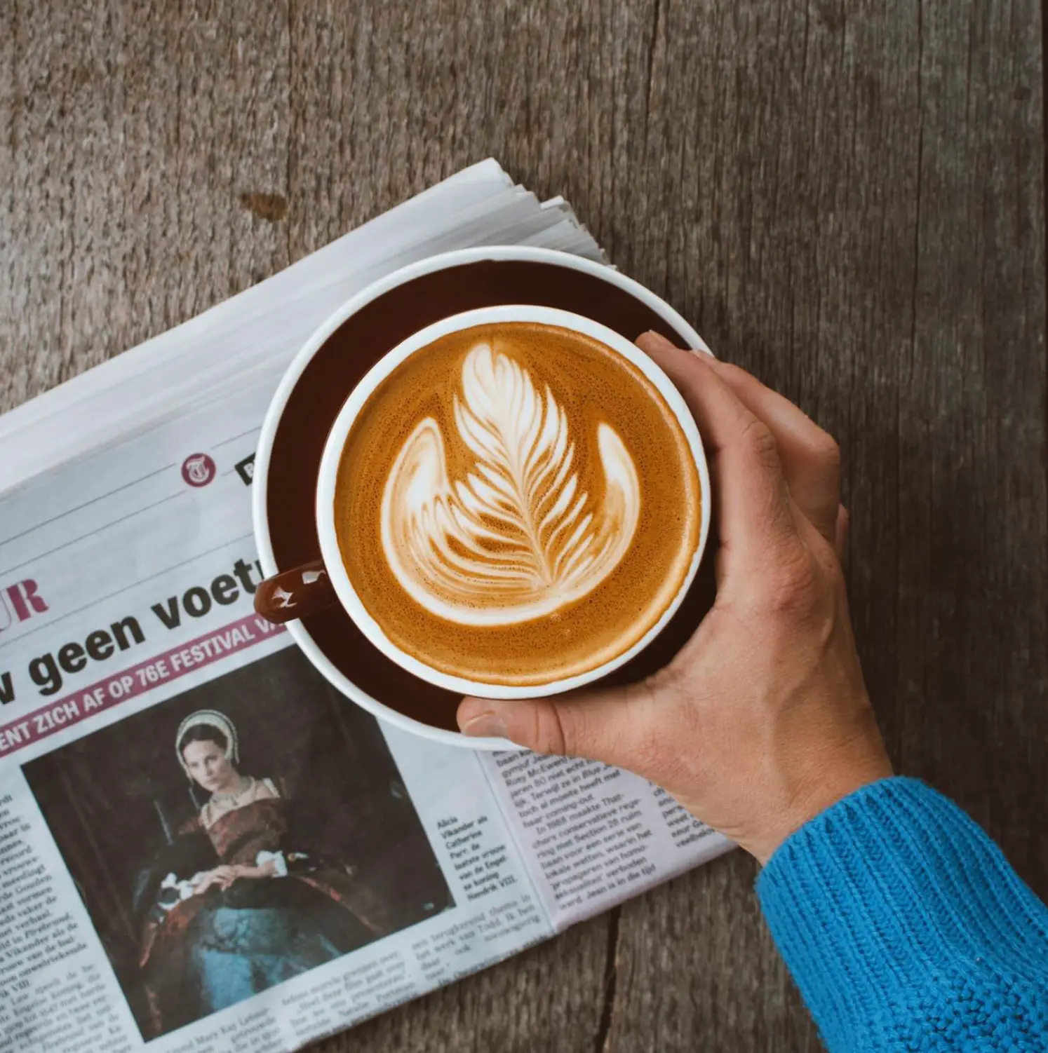 Kop koffie met latte art op een krant